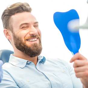 Man looking at flawless smile in mirror